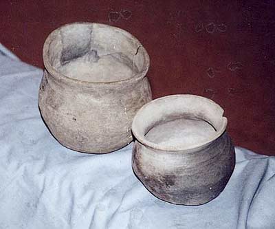 Photograph of two small, grey, spherical cooking pots with square-shaped rims made in or near Ipswich during the 9th century.