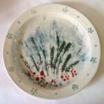 Plate by Rob Wheeler Cream coloured plate with definite rim decorated in red and green giving the impression of wheat spears and red poppies.