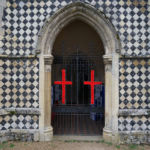 Two crucifixes faced with red poppies on the gate to the entrance porch, St. Marys church, Walsham-le-Willows.